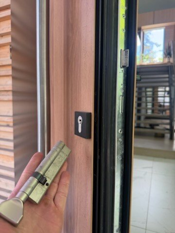 Euro profile cylinder being fitted to a modern wood and glass door
