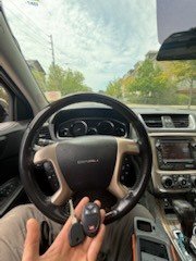 Programmed remote key held in front of the steering wheel of a GMC