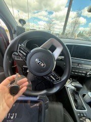 New key fob programmed on the spot, held in front of the steering wheel of a Kia