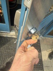 New key turned in the cylinder of an aluminum storefront door